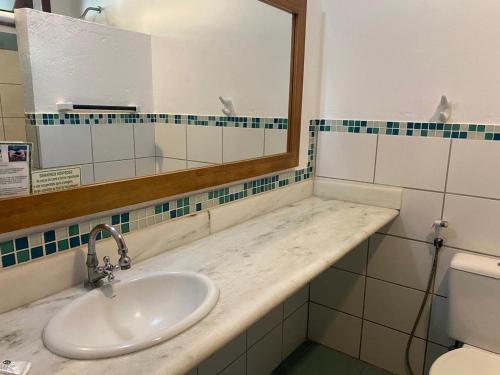 a bathroom with a sink and a mirror and a toilet at Recanto Verde Praia Hotel Juquehy in Juquei