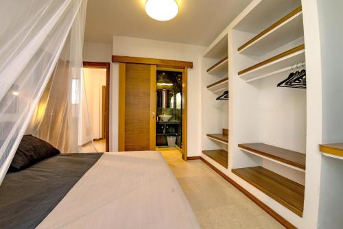 a bedroom with a bed and a closet with shelves at Casa Yuna with heated pool in El Roque in Cotillo