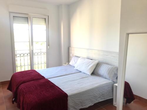 Un dormitorio con una cama con una manta roja. en Apartamento con encanto en Campo de Golf, en Sant Jordi (San Jorge)
