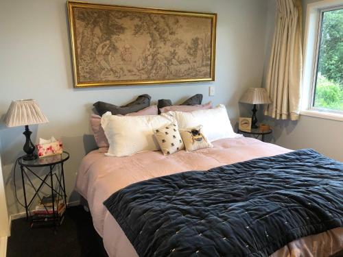 a bedroom with a bed with pillows and a painting on the wall at Executive style bedroom in Kelburn