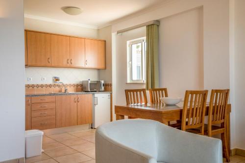a kitchen with a table and a dining room at Clube Porto Mos - Sunplace Hotels & Beach Resort in Lagos