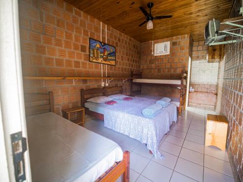 um quarto com uma cama numa parede de tijolos em Pousada São João - Estrada Parque Pantanal em Corumbá