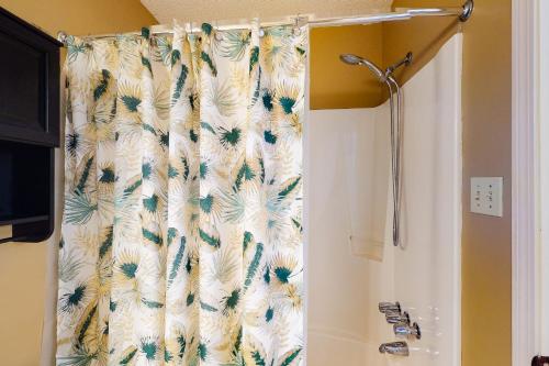 cortina de ducha con motivos florales en el baño en Lani Kai Condos, en Gulf Shores