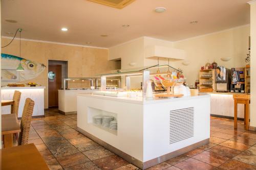 a kitchen with a white island in a room at Clube Porto Mos - Sunplace Hotels & Beach Resort in Lagos