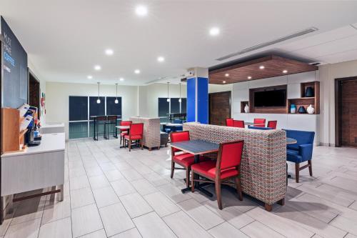 una sala da pranzo con sedie rosse e un tavolo in una hall di Holiday Inn Express & Suites Ozona by IHG a Ozona