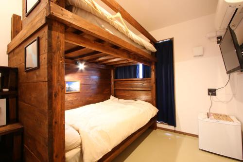 a large wooden bunk bed in a room at MARINX CLASSIC HARBORVIEW PENSION in Yaese