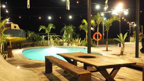 a picnic table next to a swimming pool at night at MARINX CLASSIC HARBORVIEW PENSION in Yaese