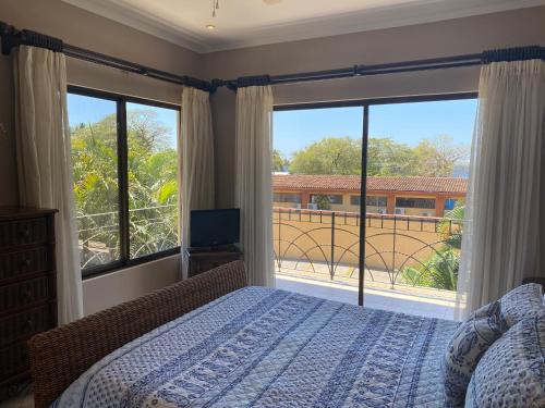 a bedroom with a bed and a large window at Sunrise 42 in Tamarindo