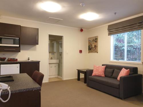a living room with a couch and a table at At Eden Park Motel in Auckland