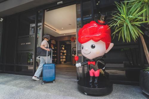 a statue of a girl with a suitcase in front of a building at Royal Rose Hotel Xinsheng in Taipei