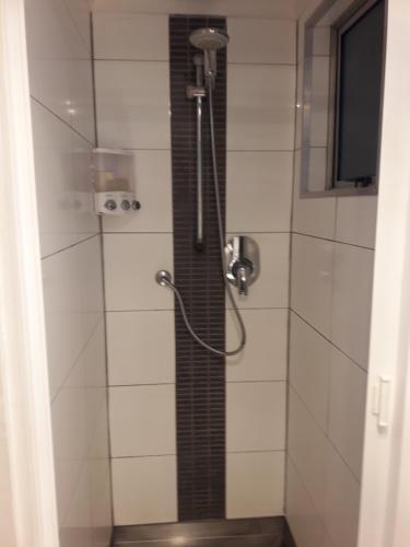 a shower with a shower head in a bathroom at The Lighthouse in Auckland