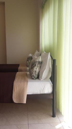 two pillows sitting on a bed next to a window at Evdokia's Apartments and Rooms in Neos Marmaras