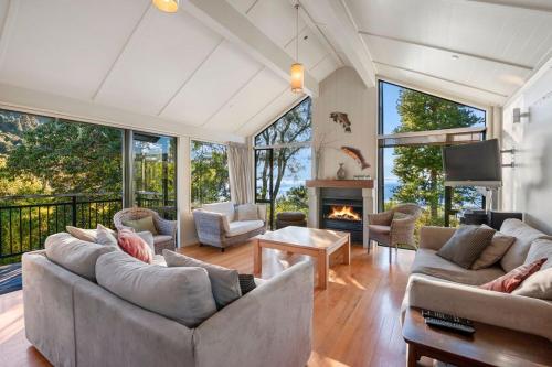 a living room with two couches and a fireplace at Puketapu - Kuratau Holiday Home in Kuratau