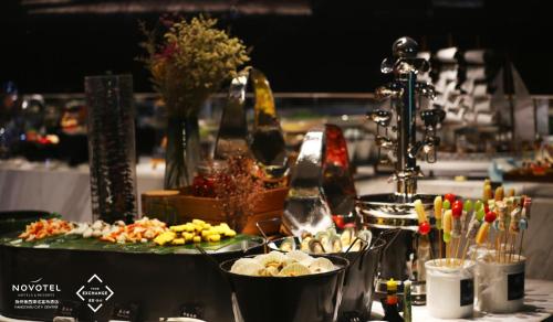 Una mesa cubierta con platos de comida sobre una mesa. en Novotel Yangzhou City Center, en Yangzhou