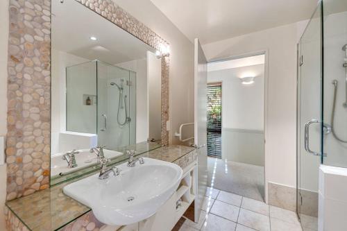 a white bathroom with a sink and a shower at Puketapu - Kuratau Holiday Home in Kuratau
