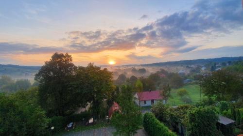an aerial view of a house in a field with the sunset at Noclegi Tyczyn in Tyczyn