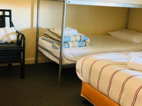 KootingalにあるKootingal Hotelのベッドルーム1室(二段ベッド2台、椅子付)