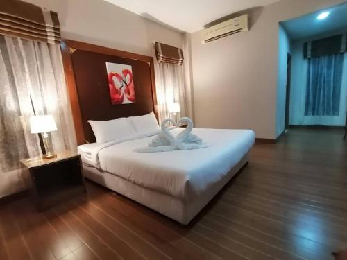 a bedroom with a bed with a swan on it at Chaithalay Khanom Resort in Ban Phang Phrao