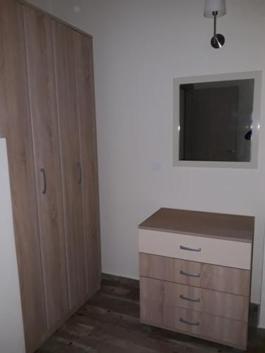 a room with a dresser and a flat screen tv at Evdokia's Apartments and Rooms in Neos Marmaras