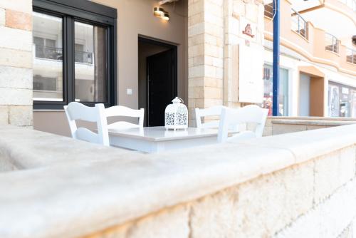 a white table and chairs on a balcony at Evdokia's Apartments and Rooms in Neos Marmaras