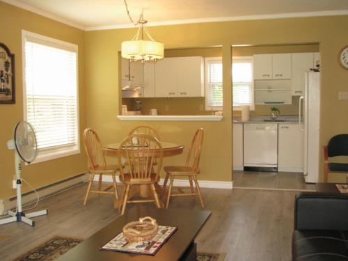 ein Wohnzimmer mit einem Tisch und Stühlen sowie eine Küche in der Unterkunft Arkadia Condo Magog in Magog-Orford