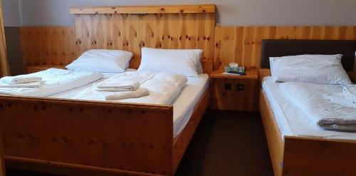 two twin beds in a room with towels on them at Hotel Zum Deutschen Eck in Velbert