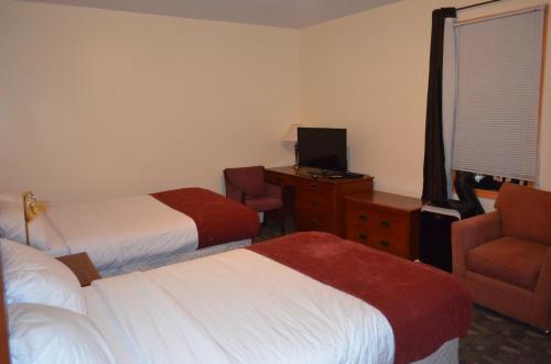a hotel room with two beds and a chair at Two Hills Inn in Two Hills