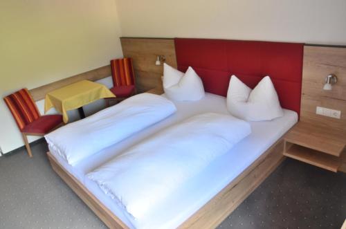a bedroom with two beds and a table and chairs at Appartements Kroner in Nauders