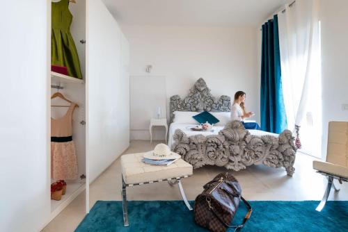 kobieta siedząca na łóżku w sypialni w obiekcie Reggia del Saraceno w Syrakuzach