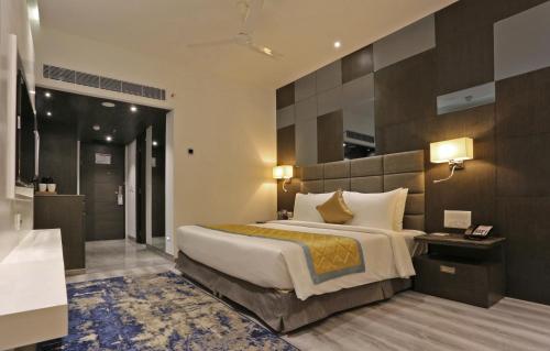 a hotel room with a large bed and a bathroom at Best Western Plus Tejvivaan in Visakhapatnam