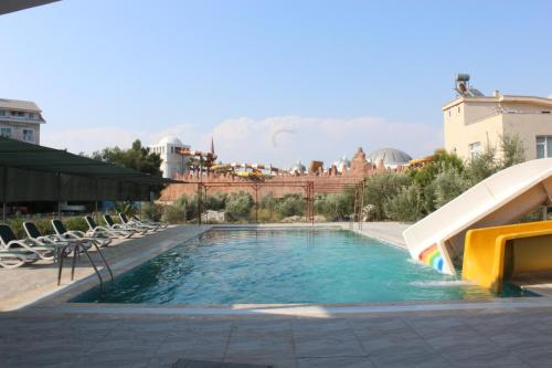een zwembad met glijbaan bij een resort bij Gül Otel in Belek