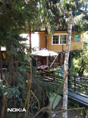 ein Haus mit einem Tisch und einem Sonnenschirm in der Unterkunft tree house in Visoko