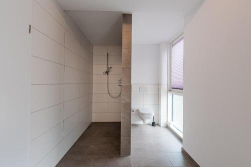 uma casa de banho com um chuveiro e um WC. em WH Boardinghouse em Papenburg