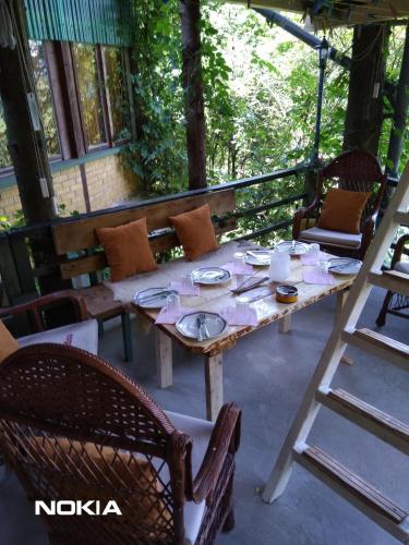 Ein Tisch und Stühle stehen auf einer Veranda in der Unterkunft tree house in Visoko