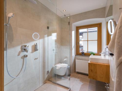 a bathroom with a shower and a toilet and a sink at Alpen Glück Hotel Unterm Rain garni in Kirchberg in Tirol