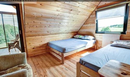 um quarto com 2 camas num chalé de madeira em Dom nad jeziorem bania plaża bezpośredni dostęp do jeziora em Burbiski