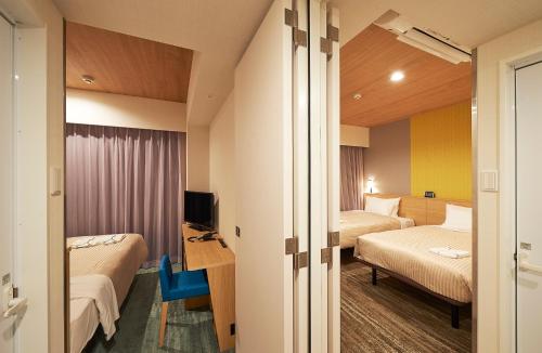 um quarto de hotel com duas camas e uma televisão em Sotetsu Fresa Inn Tokyo Tamachi em Tóquio