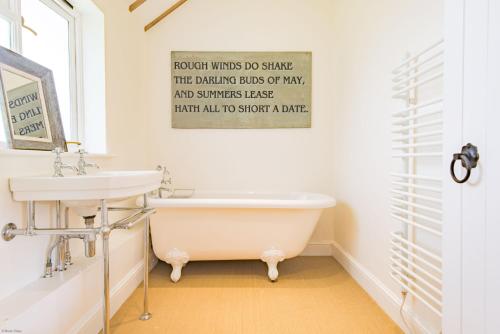 a bathroom with a bath tub and a sink at The Figgy by Bloom Stays in Ashford