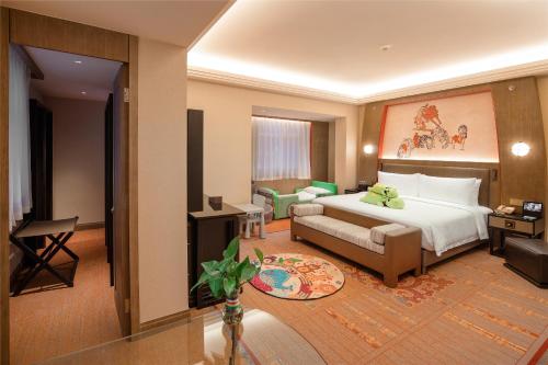 Habitación de hotel con cama y sofá en Chengdu Tibetan Hotel-Free Welcome Tibetan Tea en Chengdú