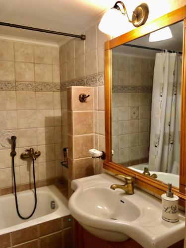 a bathroom with a sink and a tub and a mirror at Casa Victoria in Katokhórion