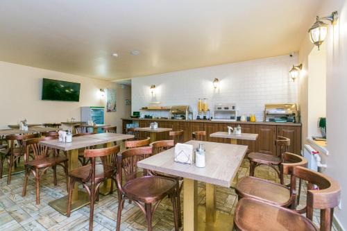 a restaurant with tables and chairs and a kitchen at Neva Delta Hotel in Saint Petersburg