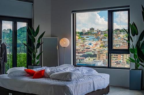 a bedroom with a bed with a view of a city at Glue Hotel in Seoul