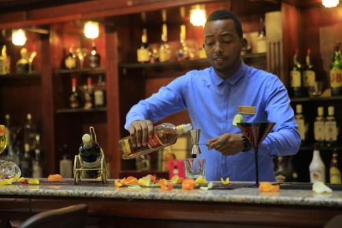 
a man in a chef's outfit pouring a glass of wine at Inter Luxury Hotel in Addis Ababa
