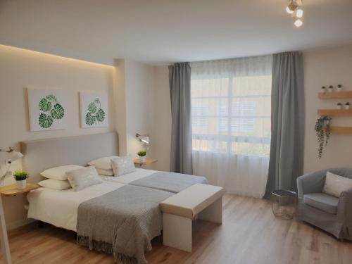 1 dormitorio con 1 cama, 1 silla y 1 ventana en Morrojable Luxury Beach Apartments en Morro del Jable