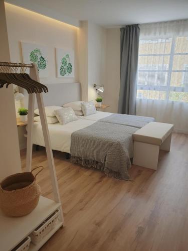 a white bedroom with a bed and a window at Morrojable Luxury Beach Apartments in Morro del Jable