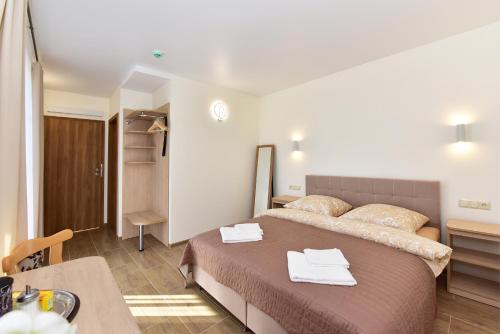 a bedroom with a large bed with towels on it at Panorama in Trakai