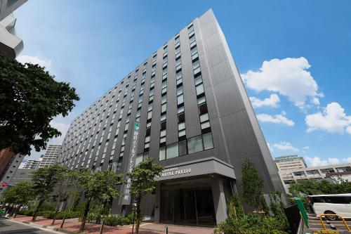 a tall building in a city at Shizutetsu Hotel Prezio Tokyo Tamachi in Tokyo