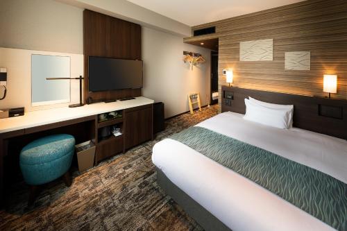 a hotel room with a bed and a television at Shizutetsu Hotel Prezio Tokyo Tamachi in Tokyo