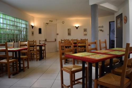 une salle à manger avec des tables et des chaises dans un restaurant dans l'établissement Cat'Hotel, à Bourg-de-Péage