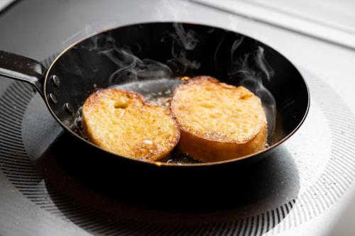two pieces of bread cooking in a frying pan at Shizutetsu Hotel Prezio Tokyo Tamachi in Tokyo